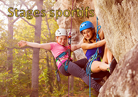 Colonies de vacances sportives, 2 jeunes adolescentes souriantes font de l'escalade et grimpent un bloc naturel